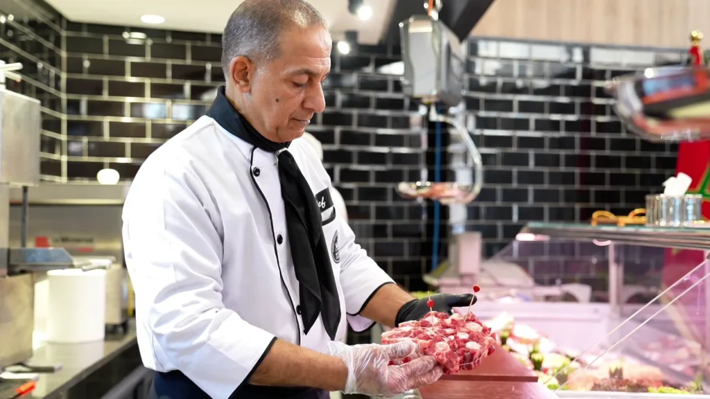 Boucher préparant une pièce de viande au comptoir