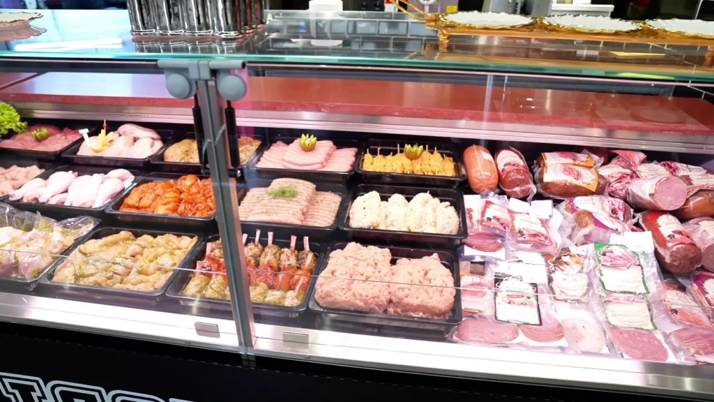 Vitrine de viandes préparées : brochettes, viandes marinées et charcuterie
