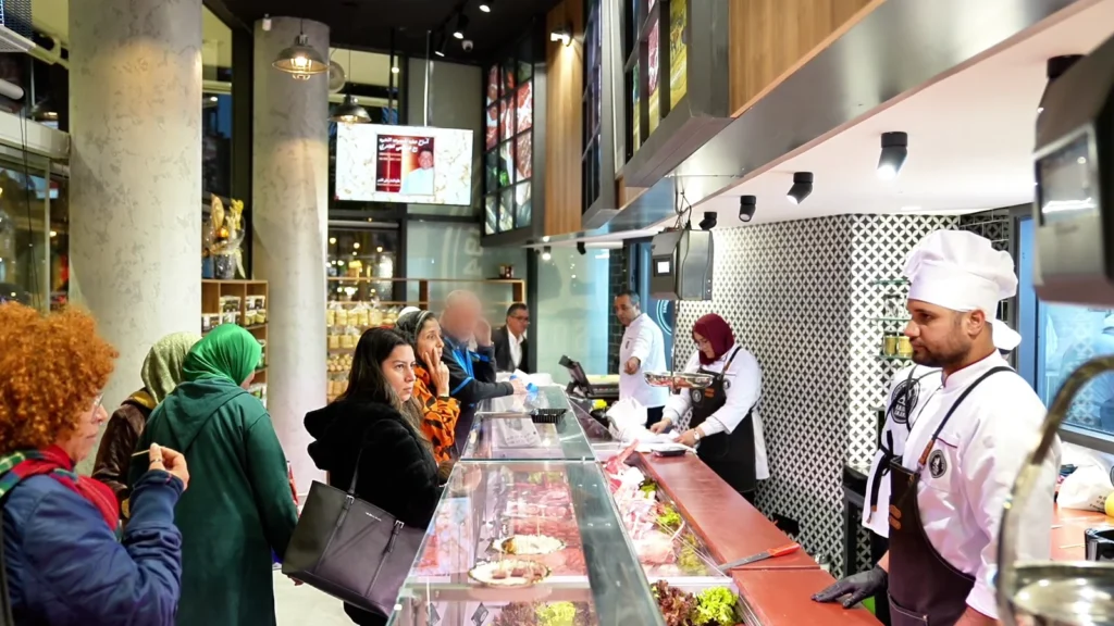 Clients au comptoir d'une boucherie, conseil du boucher